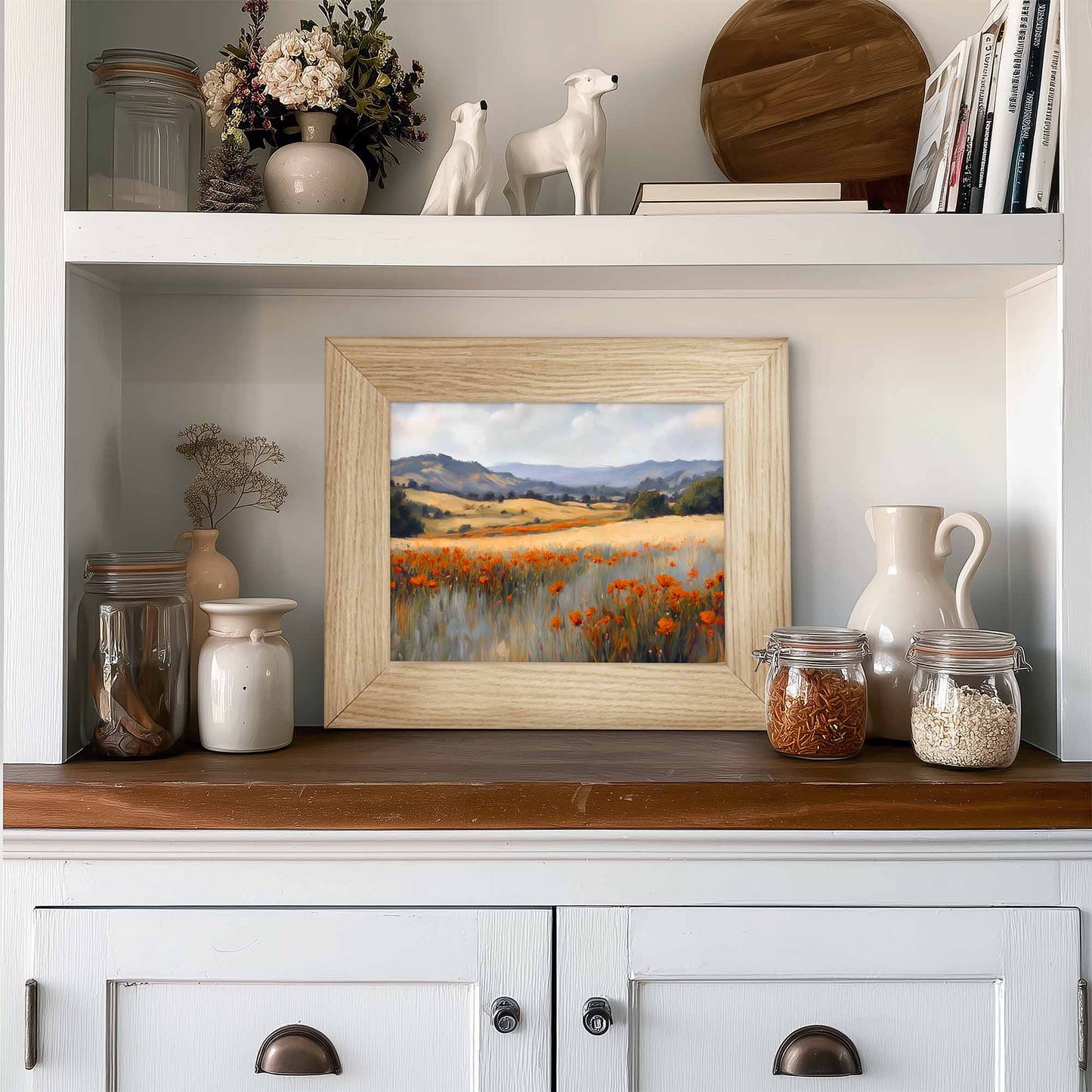 Framed landscape painting on a wooden shelf with decorative items in the kitchen