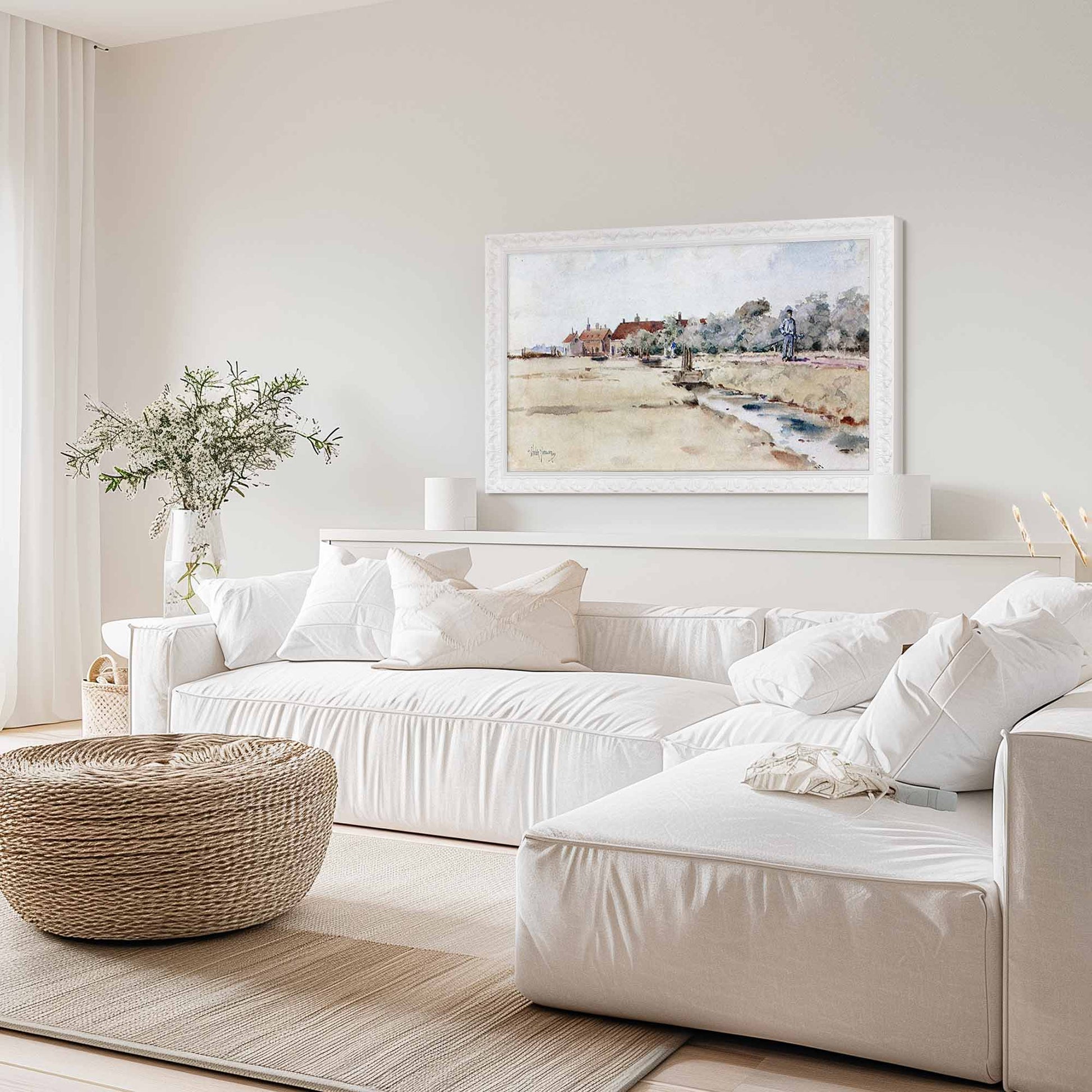 Modern living room with white sofas, a woven ottoman, and a framed landscape painting.