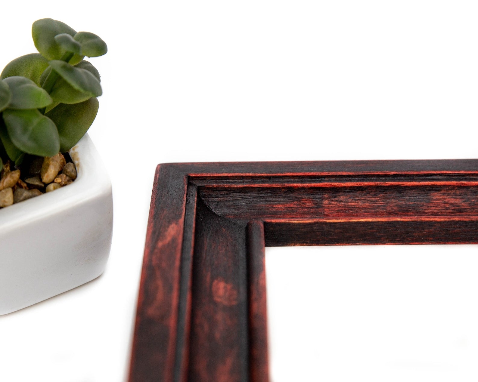 Wooden picture frame corner with a small potted plant on a white background. Reddish Black Shabby Chic Picture Frame, Hand Distressed Gallery Wall Frame, Custom Size Photo Frame A1, A2, A3, 11x14, 16x20, 18x24, 24x36