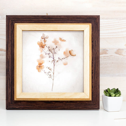 Framed artwork of flowers and branches on a wooden surface with a plant in the background. Brown + Natural Photo Frame, Wood Picture Frame, Gallery Wall Frames, Custom Size 5x7 8x10 10x10 8x12 8.5x11 11x14 12x18 18x24 20x30 A1 A2