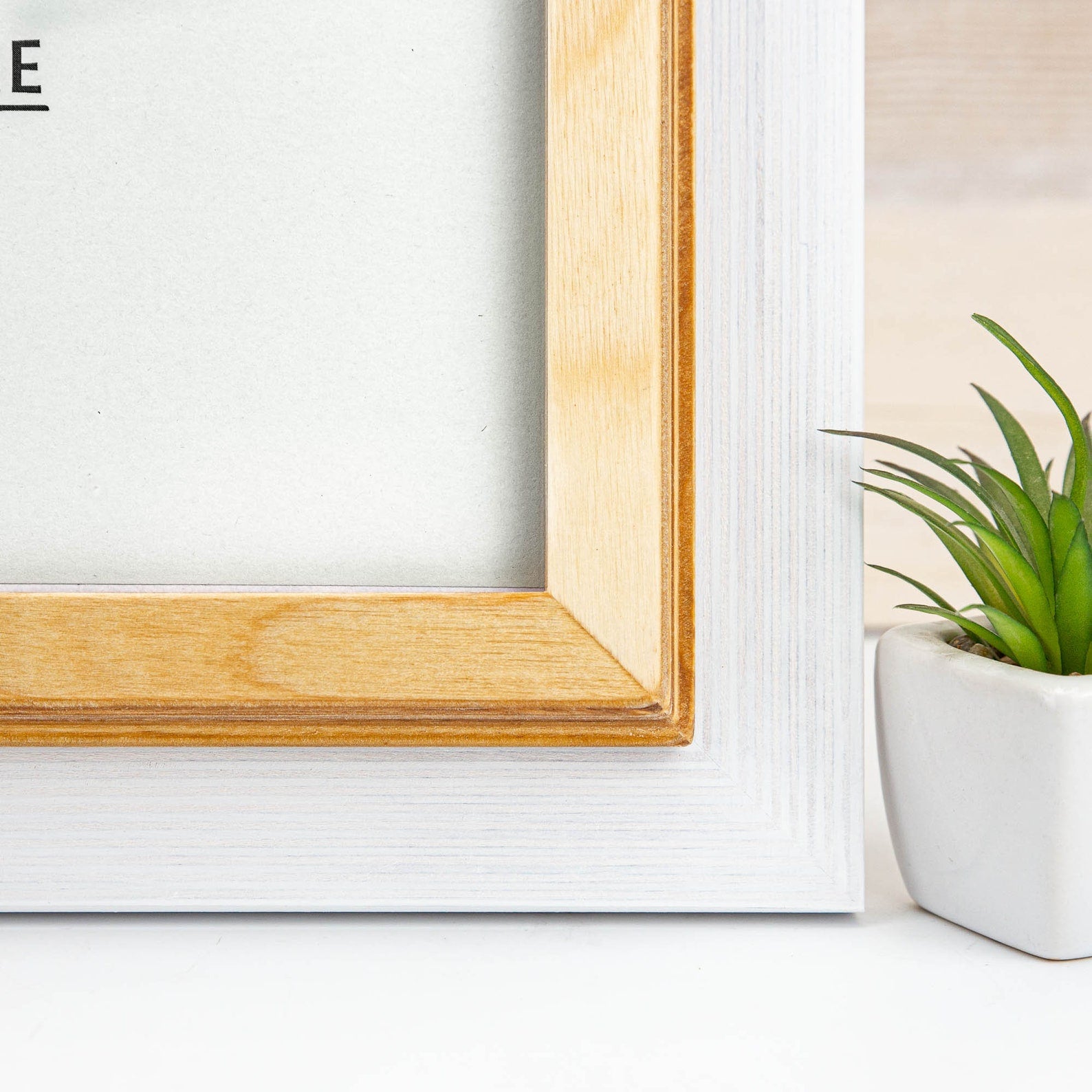 Wooden picture frame on a white wall with a plant to the right. White + Natural Custom Wooden Frame, Handmade Double Color Photo Frame, Modern Wall Frame, Poster Frame A1 A2 A3 A4 11x14 12x18 20x30 24x36
