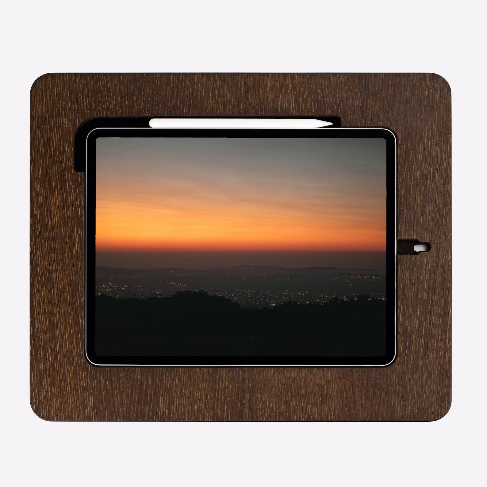 Dark brown wooden stand holding an iPad with a designated space for an apple pen.
