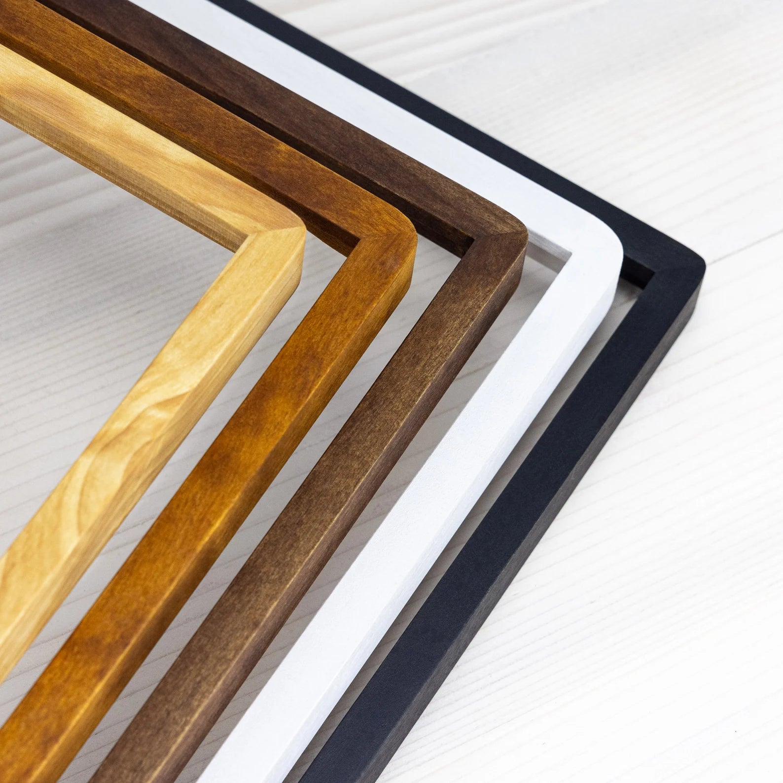 Corners of five natural wooden handcrafted picture frames.