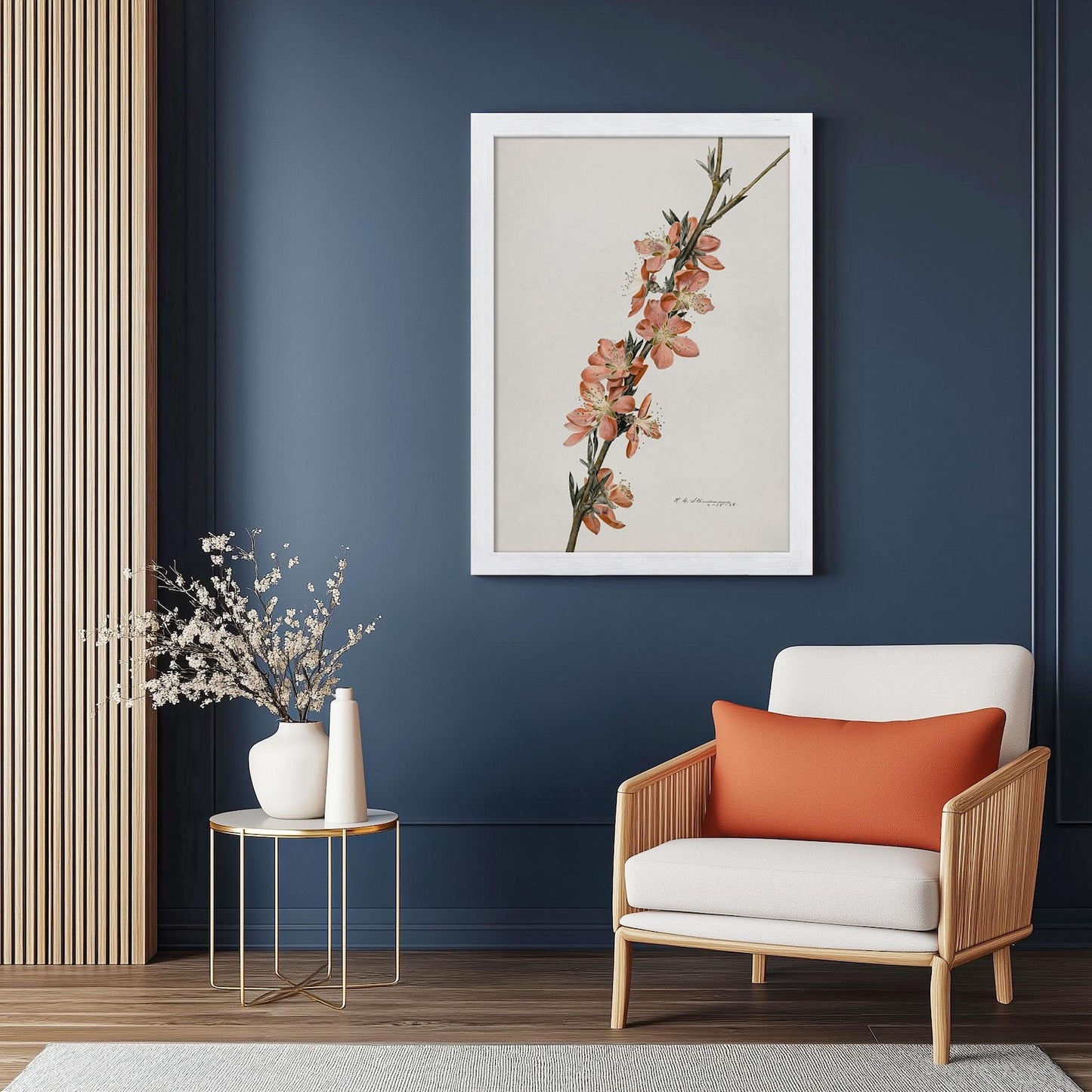 Modern living room with a framed floral print on a blue wall, a white armchair with an orange pillow, and a small round table with decorative items.