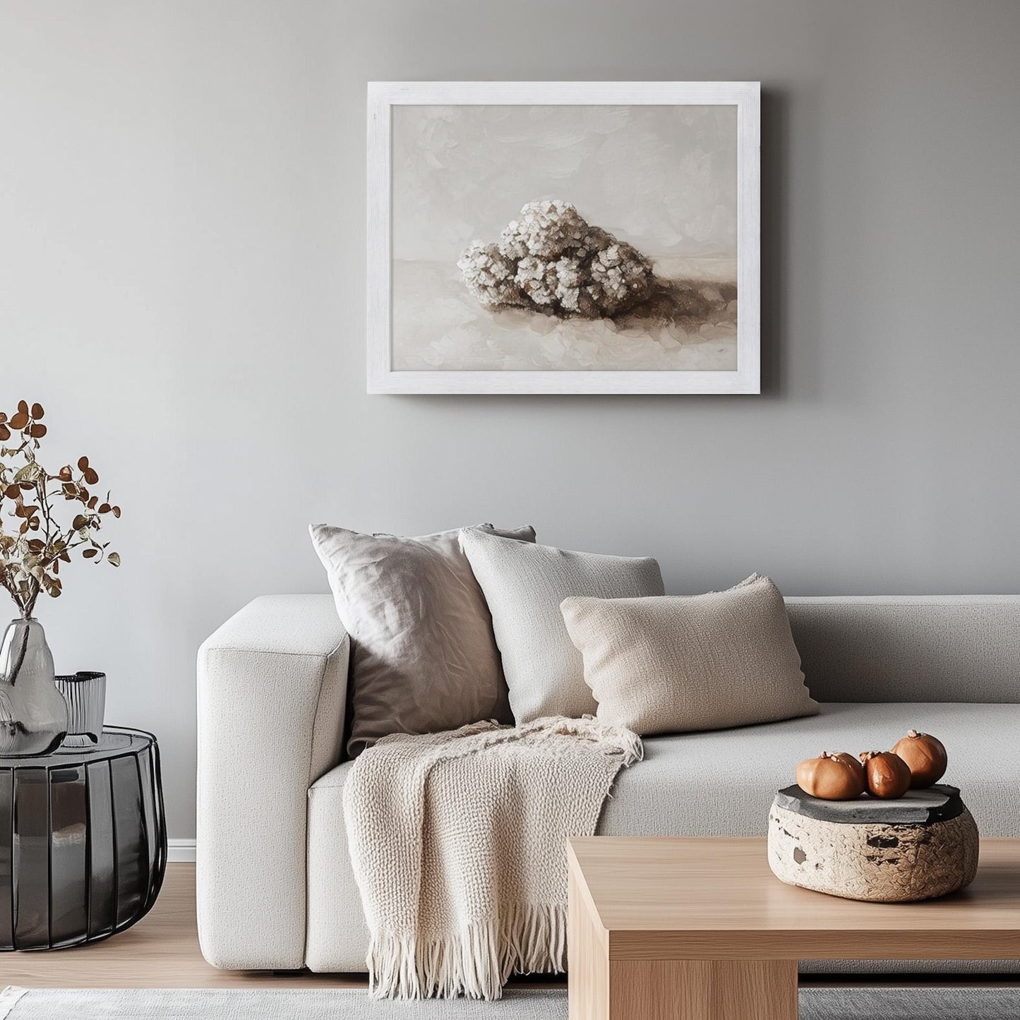 Living room with a gray sofa, decorative pillows, and a framed artwork on the wall.