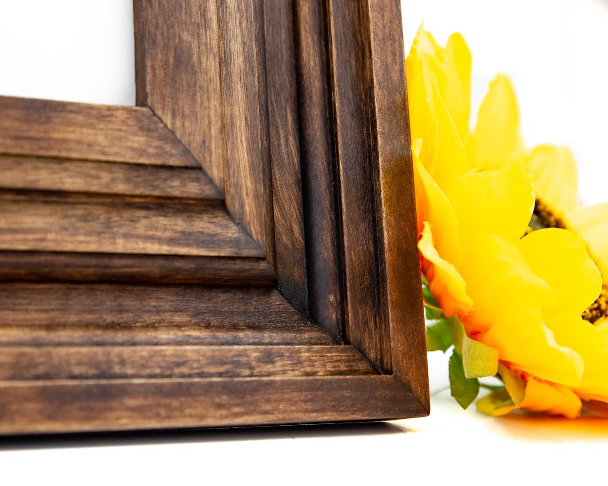 Close up of a handcrafted wooden picture frame in 3 inch wide empire style.