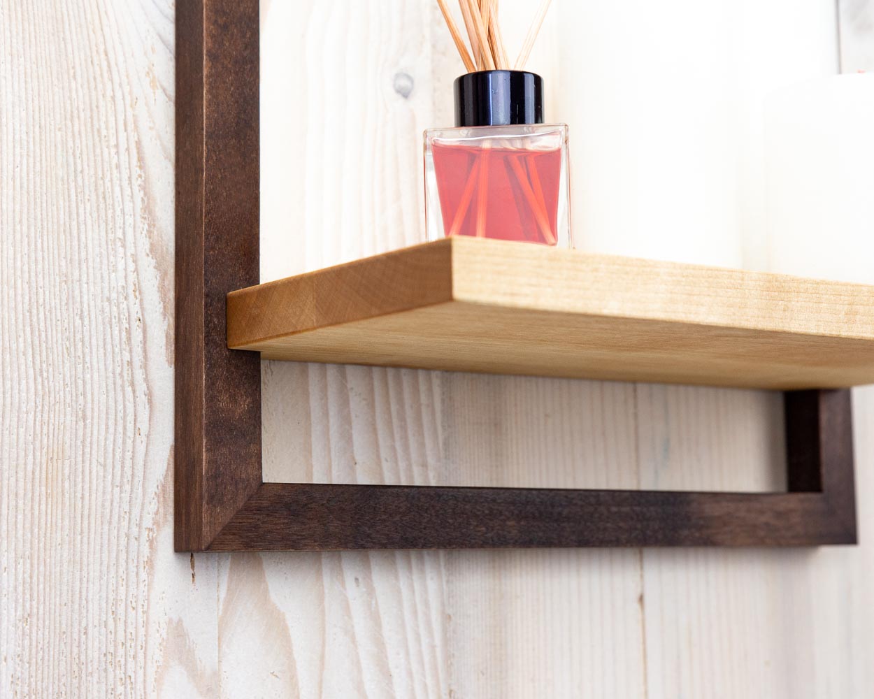 Details of dark brown wooden framed shelf holding home decor.