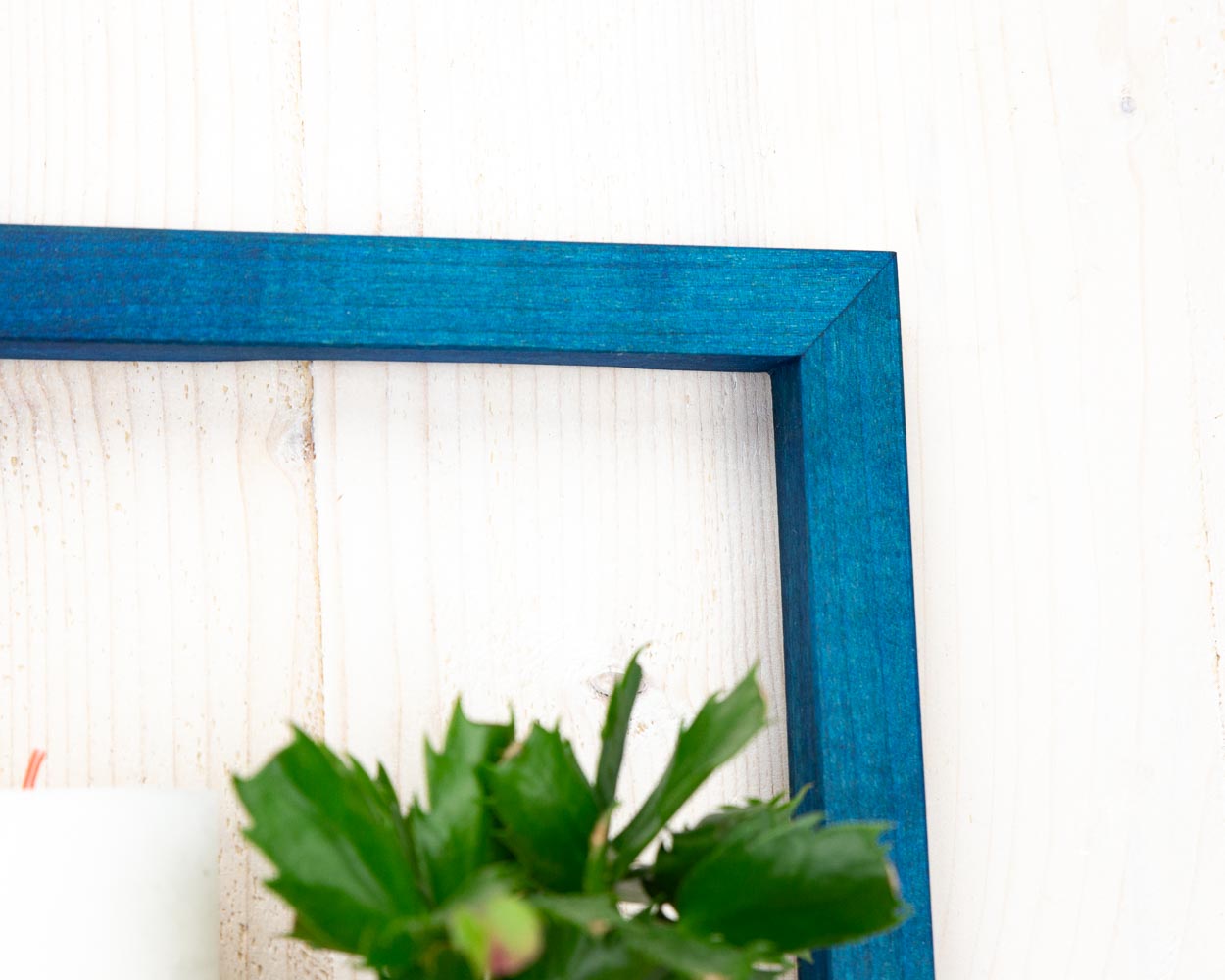 Corner of a blue wooden frame made with quality materials.