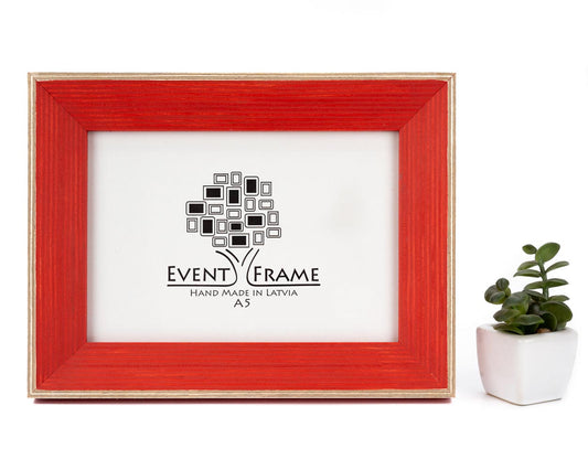 A classic light red picture frame with a white border and a black logo in the center, displayed next to a small potted plant. Red Wood Picture Frame, Hand Painted Artwork frames, Rustic Home Decor, Square 5x5 Photo Frame, Any Size A5 A4 4x6, 5x7, 8.5x11, 8x10, 8x12