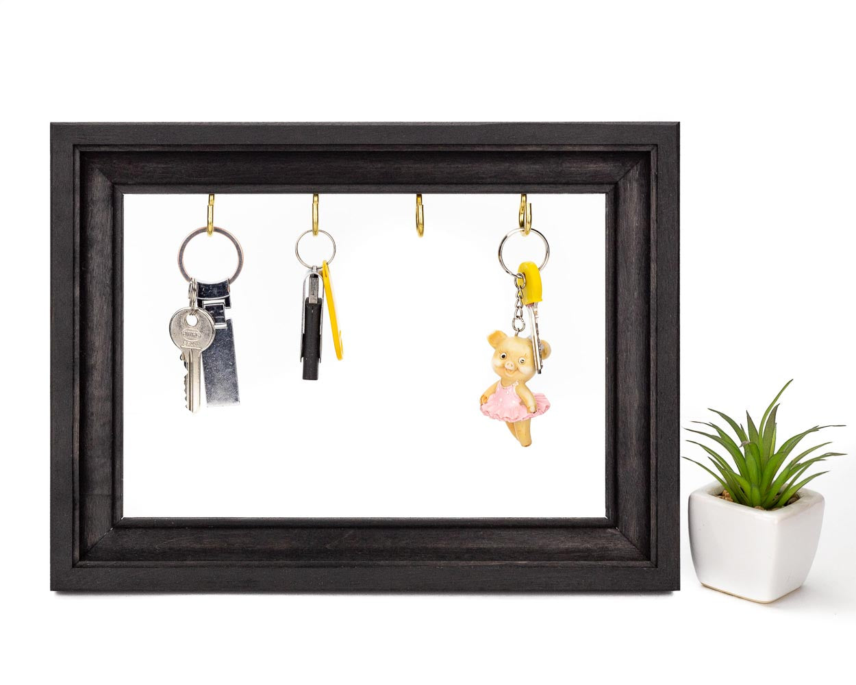 Black handcrafted wooden frame holding keys.