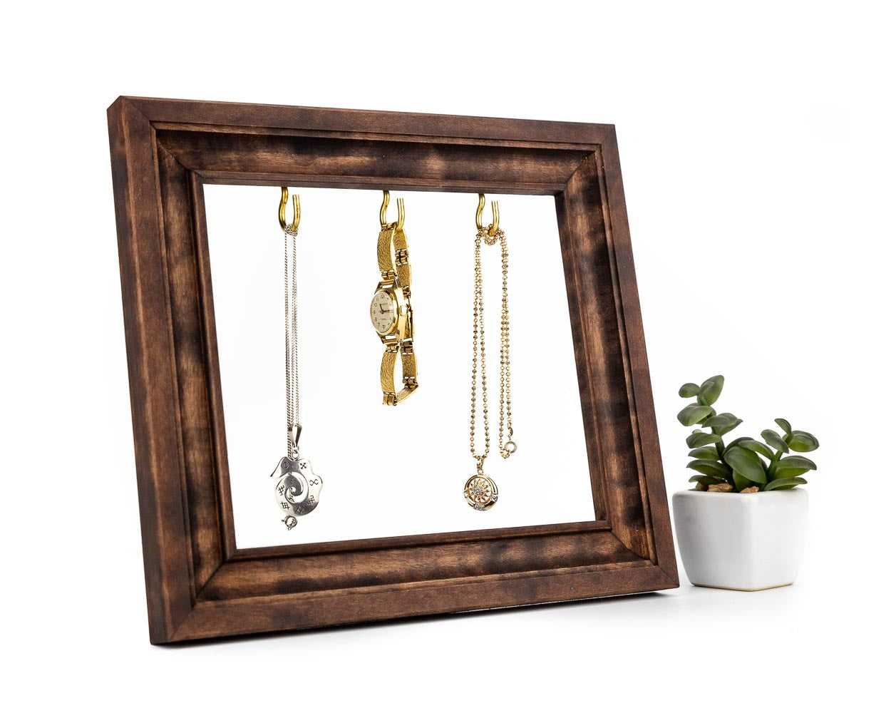 Dark brown wooden frame holding gold jewelry.
