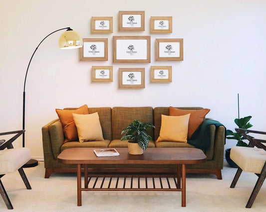 Set of natural wood handrafted quality picture frames in modern home on blank wall above couch.