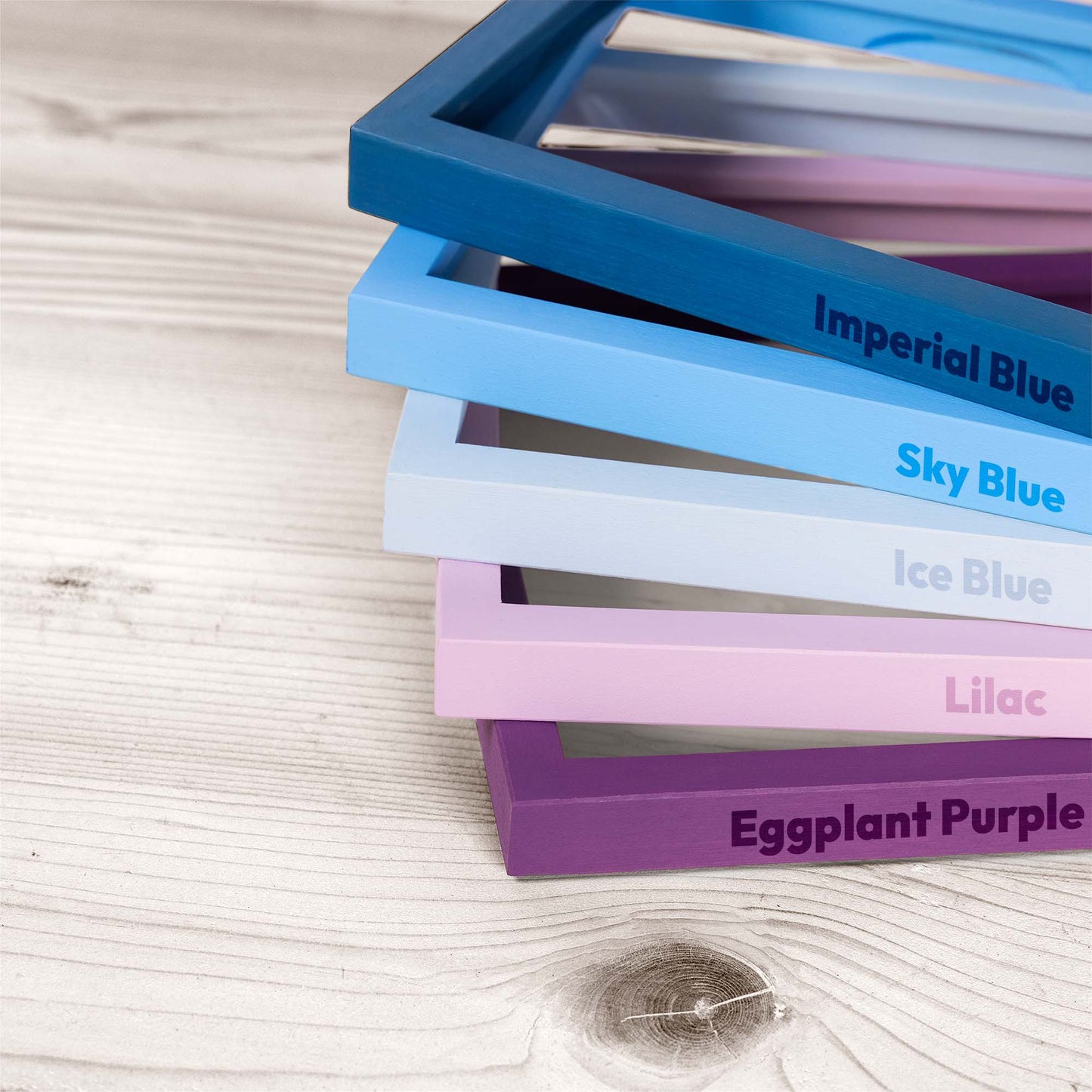 Stack of colorful picture photo frames with labels on a wooden surface