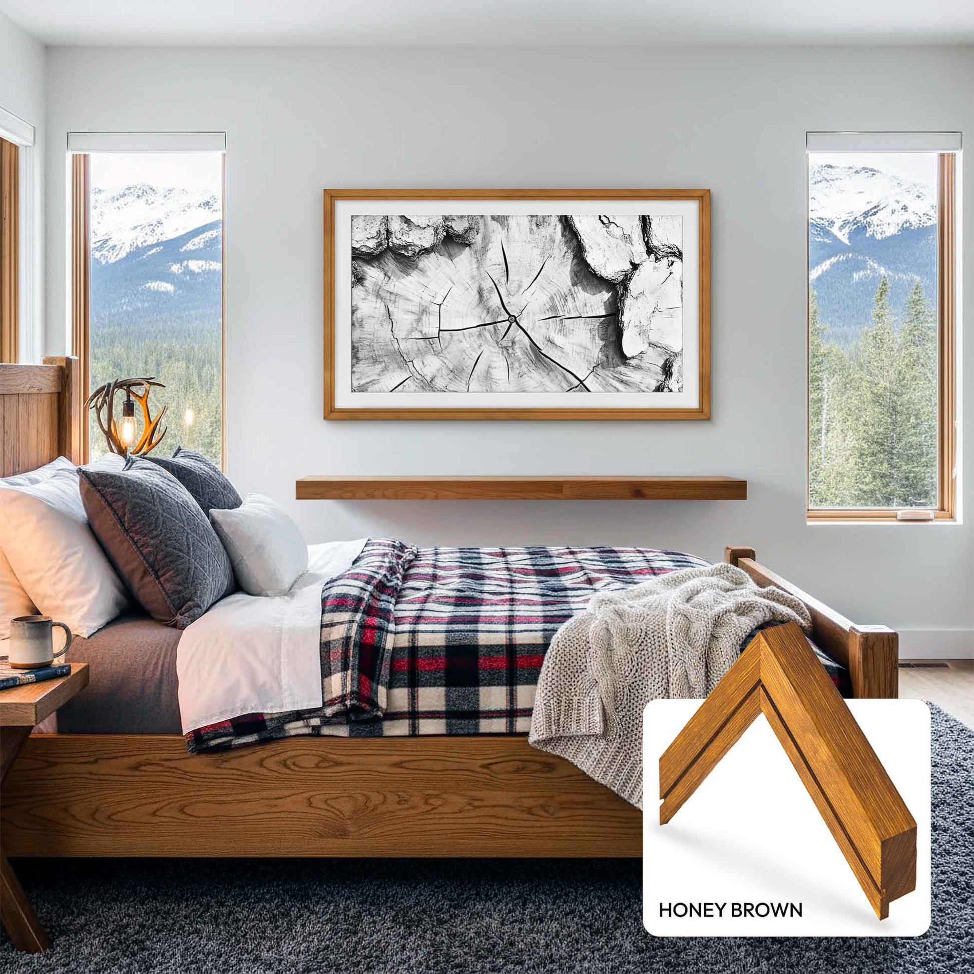 Bedroom with wooden bed, plaid blanket, and abstract art on wall.