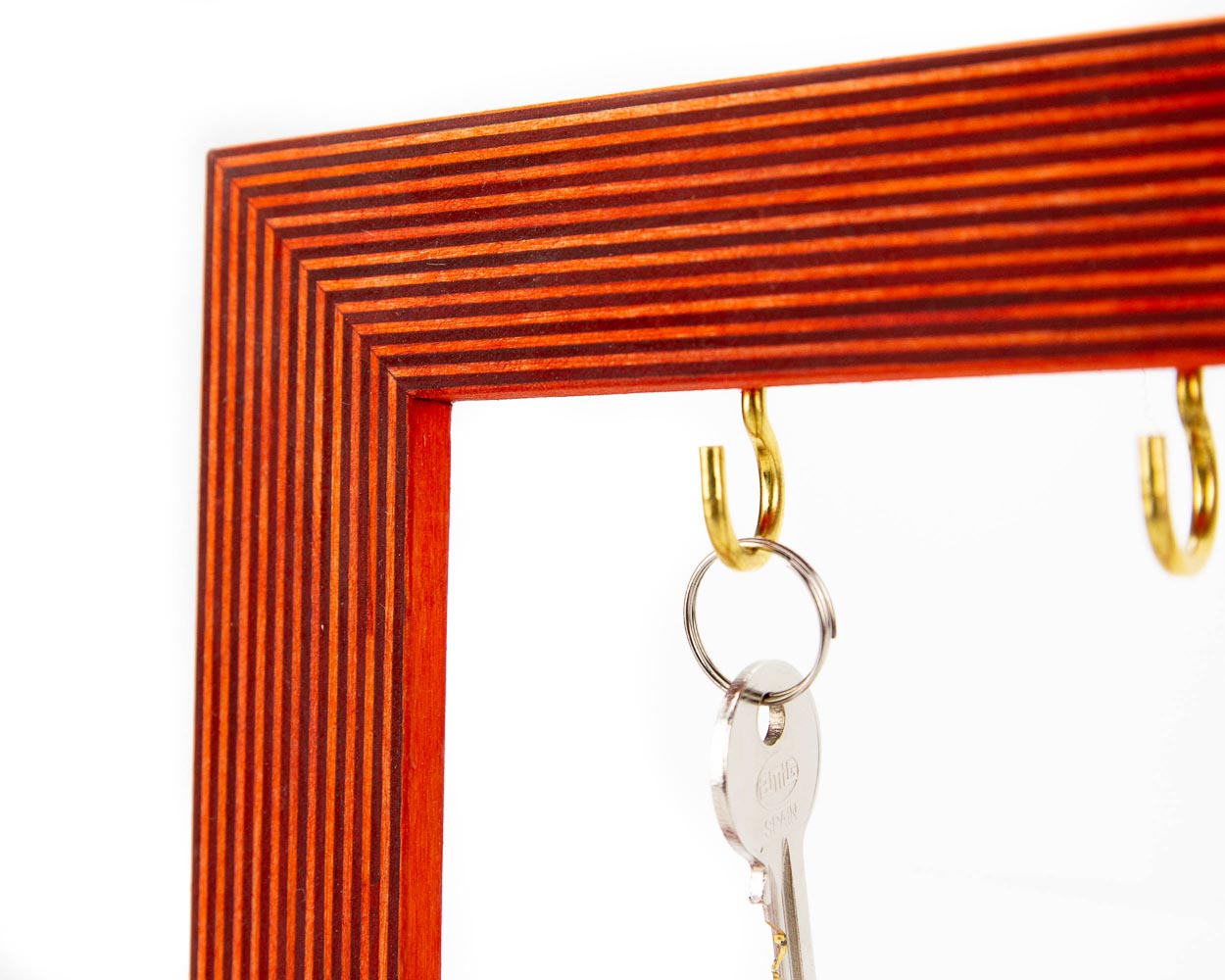 Wooden key holder frame in orange color and striped pattern.